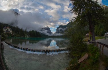 Toblacher Gölü (Lago di Dobbiaco) ve Dolomite dağları üzerinde panoramik manzara sisli bir sabah, Dolomitler, Güney Tyrol, İtalya 'nın geniş açılı renklerinde, sonbahar mevsiminde yakınlarda zirveler yapar.