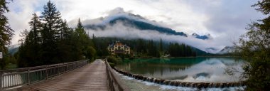 Toblacher Gölü (Lago di Dobbiaco) ve Dolomite dağları üzerinde panoramik manzara sisli bir sabah, Dolomitler, Güney Tyrol, İtalya 'nın geniş açılı renklerinde, sonbahar mevsiminde yakınlarda zirveler yapar.