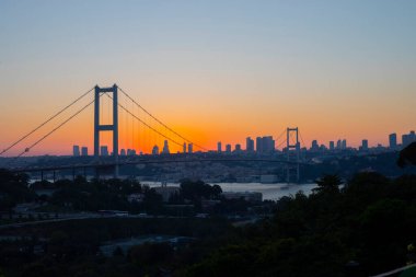 Günbatımında İstanbul Boğazı 'nın muhteşem panoramik manzarası. İstanbul Boğaz Köprüsü (15 Temmuz Şehitler Köprüsü. Türkçe: 15 Temmuz Sehitler Koprusu). Güzel peyzaj Türkiye.