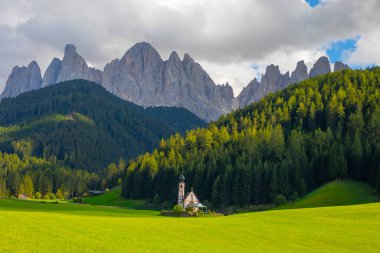 Dolomite Alpleri'nin güneşli manzarası. Güzel Dolomiti dağları ile St Johann Kilisesi, Santa Maddalena, Val Di Funes, Dolomites, İtalya.