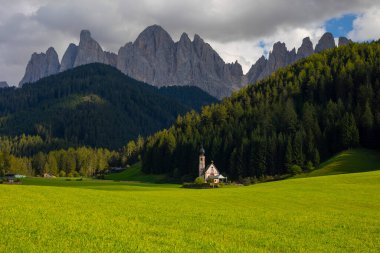 Dolomite Alpleri'nin güneşli manzarası. Güzel Dolomiti dağları ile St Johann Kilisesi, Santa Maddalena, Val Di Funes, Dolomites, İtalya.