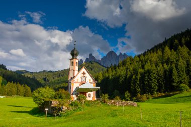 Dolomite Alpleri'nin güneşli manzarası. Güzel Dolomiti dağları ile St Johann Kilisesi, Santa Maddalena, Val Di Funes, Dolomites, İtalya.