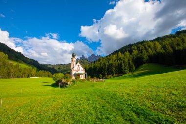 Dolomite Alpleri'nin güneşli manzarası. Güzel Dolomiti dağları ile St Johann Kilisesi, Santa Maddalena, Val Di Funes, Dolomites, İtalya.