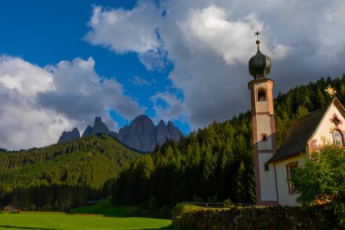 Dolomite Alpleri'nin güneşli manzarası. Güzel Dolomiti dağları ile St Johann Kilisesi, Santa Maddalena, Val Di Funes, Dolomites, İtalya.