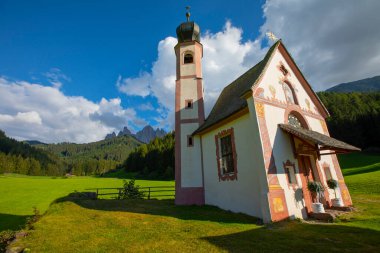 Dolomite Alpleri'nin güneşli manzarası. Güzel Dolomiti dağları ile St Johann Kilisesi, Santa Maddalena, Val Di Funes, Dolomites, İtalya.