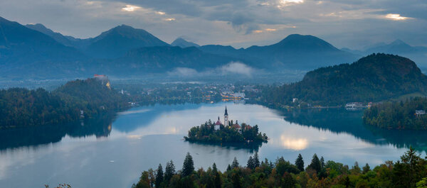 Aerial landscape photography. Colorful morning scene of Pilgrimage Church of the Assumption of Maria. Aerial autumn view of Bled lake, Julian Alps, Slovenia, Europe. Traveling concept background.