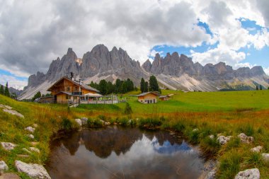 Güzel bahar Alp manzara, dağ chalets ve yüksek karlı dağlarla gün batımında, Geisler - arka planda küçük göl Odle dağ grup, Alto Adige, Dolomites, İtalya, Avrupa