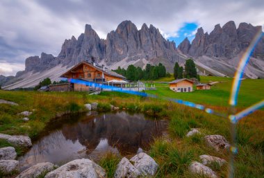 Güzel bahar Alp manzara, dağ chalets ve yüksek karlı dağlarla gün batımında, Geisler - arka planda küçük göl Odle dağ grup, Alto Adige, Dolomites, İtalya, Avrupa
