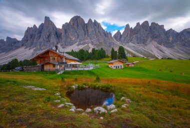Güzel bahar Alp manzara, dağ chalets ve yüksek karlı dağlarla gün batımında, Geisler - arka planda küçük göl Odle dağ grup, Alto Adige, Dolomites, İtalya, Avrupa