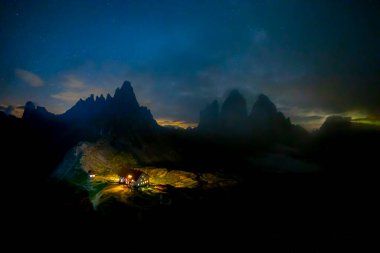 İnanılmaz yıldızlı gökyüzünün ve Lavaredo Dağları 'nın Üç Tepesi' nin zemininde içeriden yeşil çadır yandı. Ulusal Park Tre Cime di Lavaredo, Dolomitler, İtalya. Peyzaj fotoğrafçılığı