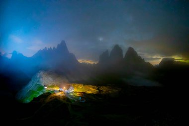 İnanılmaz yıldızlı gökyüzünün ve Lavaredo Dağları 'nın Üç Tepesi' nin zemininde içeriden yeşil çadır yandı. Ulusal Park Tre Cime di Lavaredo, Dolomitler, İtalya. Peyzaj fotoğrafçılığı