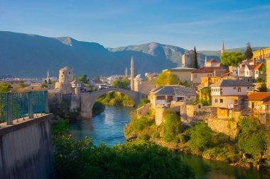 Mostar Köprüsü, evler ve minarelerle gün batımında Mostar 'ın muhteşem Skyline' ı. Konum: Mostar, Old Town, Bosna-Hersek, Avrupa