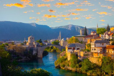 Mostar Köprüsü, evler ve minarelerle gün batımında Mostar 'ın muhteşem Skyline' ı. Konum: Mostar, Old Town, Bosna-Hersek, Avrupa