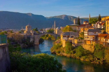 Mostar Köprüsü, evler ve minarelerle gün batımında Mostar 'ın muhteşem Skyline' ı. Konum: Mostar, Old Town, Bosna-Hersek, Avrupa