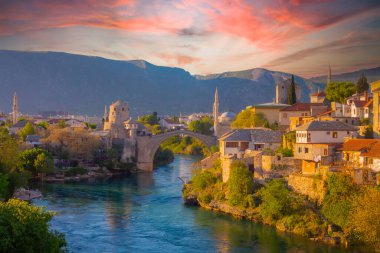 Mostar Köprüsü, evler ve minarelerle gün batımında Mostar 'ın muhteşem Skyline' ı. Konum: Mostar, Old Town, Bosna-Hersek, Avrupa