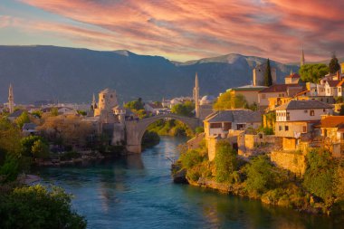 Mostar Köprüsü, evler ve minarelerle gün batımında Mostar 'ın muhteşem Skyline' ı. Konum: Mostar, Old Town, Bosna-Hersek, Avrupa
