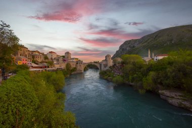 Mostar Köprüsü, evler ve minarelerle gün batımında Mostar 'ın muhteşem Skyline' ı. Konum: Mostar, Old Town, Bosna-Hersek, Avrupa