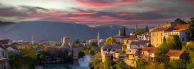 Mostar Köprüsü, evler ve minarelerle gün batımında Mostar 'ın muhteşem Skyline' ı. Konum: Mostar, Old Town, Bosna-Hersek, Avrupa