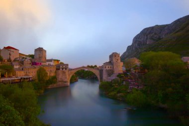 Mostar Köprüsü, evler ve minarelerle gün batımında Mostar 'ın muhteşem Skyline' ı. Konum: Mostar, Old Town, Bosna-Hersek, Avrupa
