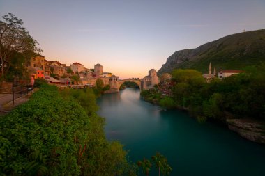 Mostar Köprüsü, evler ve minarelerle gün batımında Mostar 'ın muhteşem Skyline' ı. Konum: Mostar, Old Town, Bosna-Hersek, Avrupa
