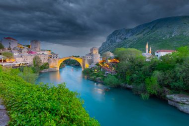 Mostar Köprüsü, evler ve minarelerle gün batımında Mostar 'ın muhteşem Skyline' ı. Konum: Mostar, Old Town, Bosna-Hersek, Avrupa