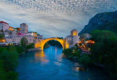 Mostar Köprüsü, evler ve minarelerle gün batımında Mostar 'ın muhteşem Skyline' ı. Konum: Mostar, Old Town, Bosna-Hersek, Avrupa
