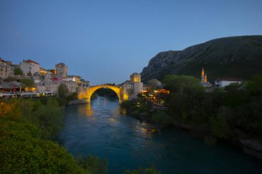 Mostar Köprüsü, evler ve minarelerle gün batımında Mostar 'ın muhteşem Skyline' ı. Konum: Mostar, Old Town, Bosna-Hersek, Avrupa