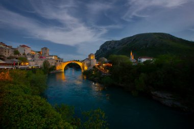 Mostar Köprüsü, evler ve minarelerle gün batımında Mostar 'ın muhteşem Skyline' ı. Konum: Mostar, Old Town, Bosna-Hersek, Avrupa