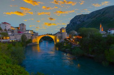 Mostar Köprüsü, evler ve minarelerle gün batımında Mostar 'ın muhteşem Skyline' ı. Konum: Mostar, Old Town, Bosna-Hersek, Avrupa