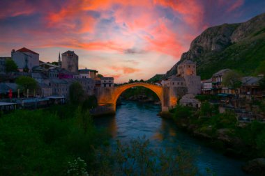 Mostar Köprüsü, evler ve minarelerle gün batımında Mostar 'ın muhteşem Skyline' ı. Konum: Mostar, Old Town, Bosna-Hersek, Avrupa