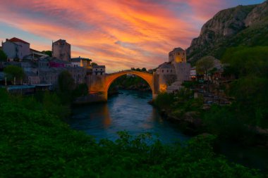 Mostar Köprüsü, evler ve minarelerle gün batımında Mostar 'ın muhteşem Skyline' ı. Konum: Mostar, Old Town, Bosna-Hersek, Avrupa