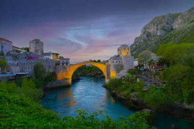 Mostar Köprüsü, evler ve minarelerle gün batımında Mostar 'ın muhteşem Skyline' ı. Konum: Mostar, Old Town, Bosna-Hersek, Avrupa