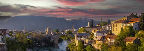 Mostar Köprüsü, evler ve minarelerle gün batımında Mostar 'ın muhteşem Skyline' ı. Konum: Mostar, Old Town, Bosna-Hersek, Avrupa