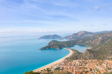 Blue Lagoon Ölüdeniz, Türkiye'de inanılmaz hava görünümünü. Dağları, yeşil orman, masmavi su, kumlu plajı ve mavi gökyüzünde parlak güneşli bir günde, yaz yatay. Arka plan seyahat. Üstten görünüm. Doğa