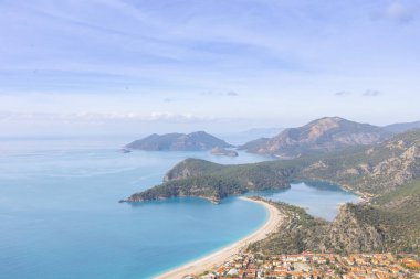 Blue Lagoon Ölüdeniz, Türkiye'de inanılmaz hava görünümünü. Dağları, yeşil orman, masmavi su, kumlu plajı ve mavi gökyüzünde parlak güneşli bir günde, yaz yatay. Arka plan seyahat. Üstten görünüm. Doğa