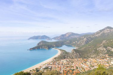 Blue Lagoon Ölüdeniz, Türkiye'de inanılmaz hava görünümünü. Dağları, yeşil orman, masmavi su, kumlu plajı ve mavi gökyüzünde parlak güneşli bir günde, yaz yatay. Arka plan seyahat. Üstten görünüm. Doğa