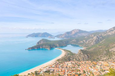Blue Lagoon Ölüdeniz, Türkiye'de inanılmaz hava görünümünü. Dağları, yeşil orman, masmavi su, kumlu plajı ve mavi gökyüzünde parlak güneşli bir günde, yaz yatay. Arka plan seyahat. Üstten görünüm. Doğa