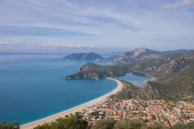Blue Lagoon Ölüdeniz, Türkiye'de inanılmaz hava görünümünü. Dağları, yeşil orman, masmavi su, kumlu plajı ve mavi gökyüzünde parlak güneşli bir günde, yaz yatay. Arka plan seyahat. Üstten görünüm. Doğa