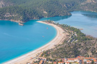 Blue Lagoon Ölüdeniz, Türkiye'de inanılmaz hava görünümünü. Dağları, yeşil orman, masmavi su, kumlu plajı ve mavi gökyüzünde parlak güneşli bir günde, yaz yatay. Arka plan seyahat. Üstten görünüm. Doğa