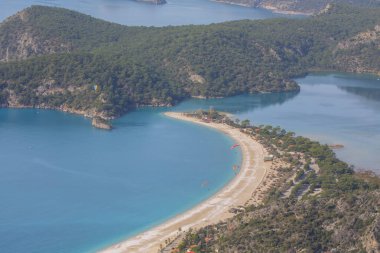 Blue Lagoon Ölüdeniz, Türkiye'de inanılmaz hava görünümünü. Dağları, yeşil orman, masmavi su, kumlu plajı ve mavi gökyüzünde parlak güneşli bir günde, yaz yatay. Arka plan seyahat. Üstten görünüm. Doğa