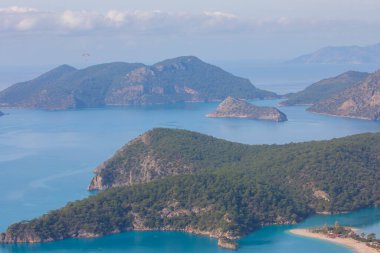Blue Lagoon Ölüdeniz, Türkiye'de inanılmaz hava görünümünü. Dağları, yeşil orman, masmavi su, kumlu plajı ve mavi gökyüzünde parlak güneşli bir günde, yaz yatay. Arka plan seyahat. Üstten görünüm. Doğa