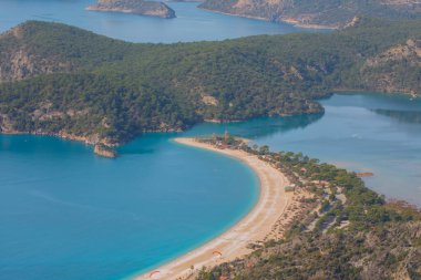 Blue Lagoon Ölüdeniz, Türkiye'de inanılmaz hava görünümünü. Dağları, yeşil orman, masmavi su, kumlu plajı ve mavi gökyüzünde parlak güneşli bir günde, yaz yatay. Arka plan seyahat. Üstten görünüm. Doğa