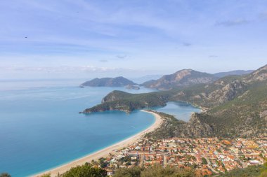 Blue Lagoon Ölüdeniz, Türkiye'de inanılmaz hava görünümünü. Dağları, yeşil orman, masmavi su, kumlu plajı ve mavi gökyüzünde parlak güneşli bir günde, yaz yatay. Arka plan seyahat. Üstten görünüm. Doğa