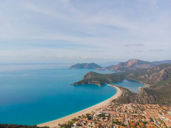Blue Lagoon Ölüdeniz, Türkiye'de inanılmaz hava görünümünü. Dağları, yeşil orman, masmavi su, kumlu plajı ve mavi gökyüzünde parlak güneşli bir günde, yaz yatay. Arka plan seyahat. Üstten görünüm. Doğa