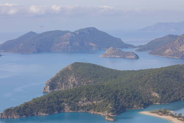 Blue Lagoon Ölüdeniz, Türkiye'de inanılmaz hava görünümünü. Dağları, yeşil orman, masmavi su, kumlu plajı ve mavi gökyüzünde parlak güneşli bir günde, yaz yatay. Arka plan seyahat. Üstten görünüm. Doğa