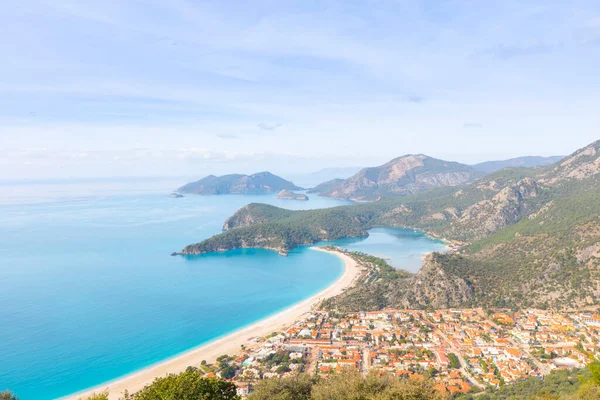 Blue Lagoon Ölüdeniz, Türkiye'de inanılmaz hava görünümünü. Dağları, yeşil orman, masmavi su, kumlu plajı ve mavi gökyüzünde parlak güneşli bir günde, yaz yatay. Arka plan seyahat. Üstten görünüm. Doğa