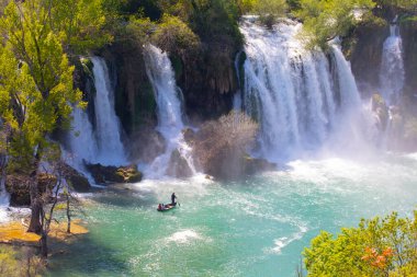 Güney Bosna-Hersek 'te Kravica şelalelerinin altında kürek çeken küçük bir tekne.