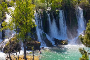 Güney Bosna-Hersek 'te Kravica şelalelerinin altında kürek çeken küçük bir tekne.