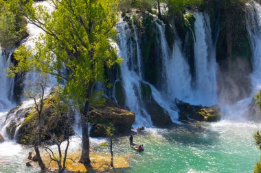 Güney Bosna-Hersek 'te Kravica şelalelerinin altında kürek çeken küçük bir tekne.