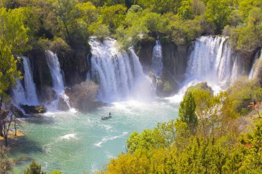 Güney Bosna-Hersek 'te Kravica şelalelerinin altında kürek çeken küçük bir tekne.